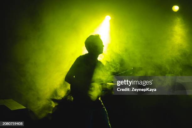 silhouette of a guitarist on stage light and smoke effects. - stage light stock pictures, royalty-free photos & images