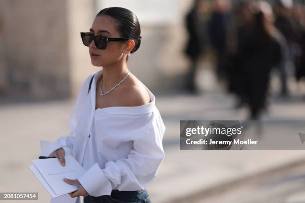Guest is seen wearing a white blouse, denim jeans and black sunglasses and a silver necklace chain outside Christian Dior during the Womenswear...