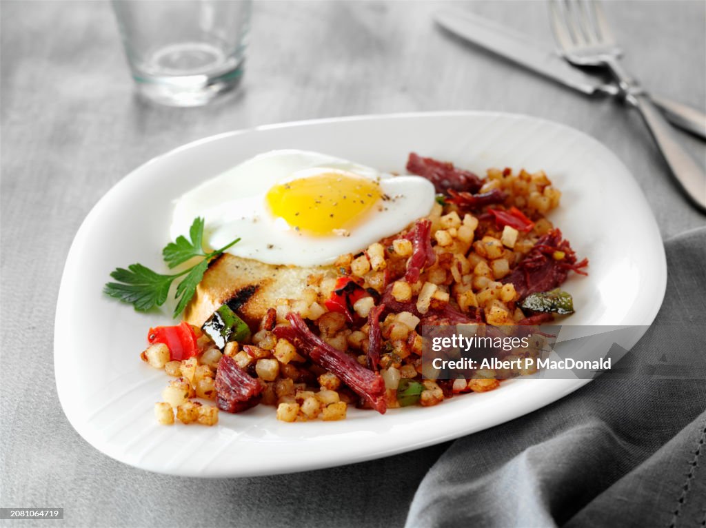 Corned beef hash with a fried egg and toast