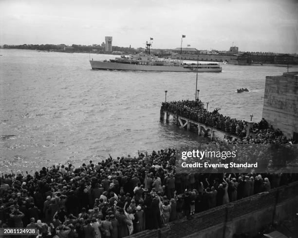 Royal Navy anti-aircraft frigate HMS 'Surprise' being waved by crowds of people as she leaves Portsmouth Harbour to join the Coronation Fleet Review...