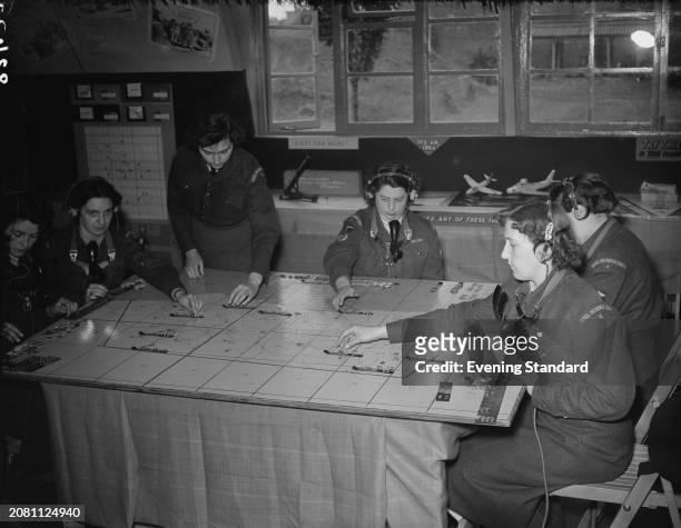 Women of the Royal Observer Corps at work tracking flights over the UK using markers on a map, RAF Bentley Priory, Harrow, London, July 17th 1953.