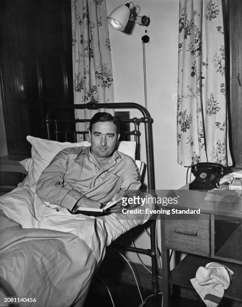 Cricketer and footballer Denis Compton in a hospital bed with a book, November 9th 1955. Compton was in hospital for an operation to replace his...