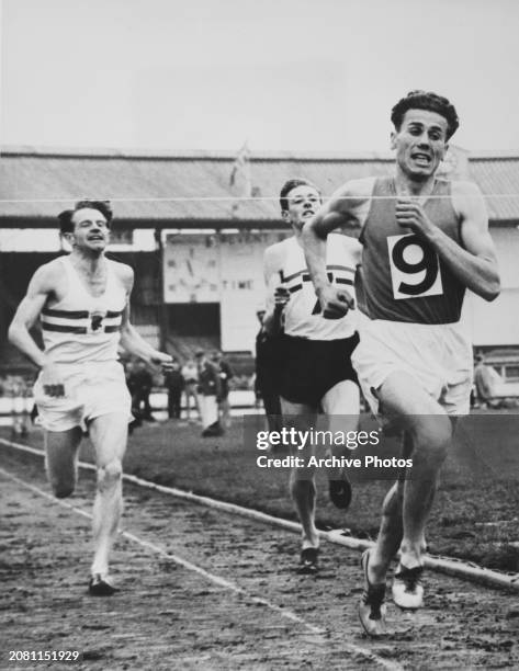 Hungarian athlete Laszlo Tabori ahead of British athletes Chris Chataway and Brian Hewson during the mile run of the British Games Meeting at White...