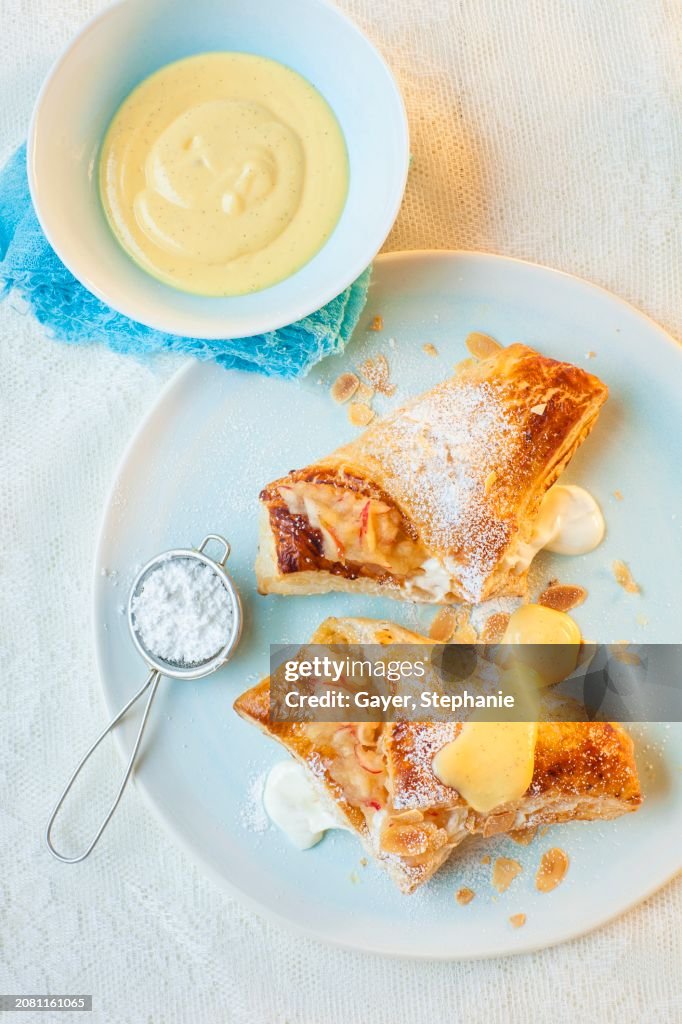 Apple and quark turnovers with icing sugar and custard