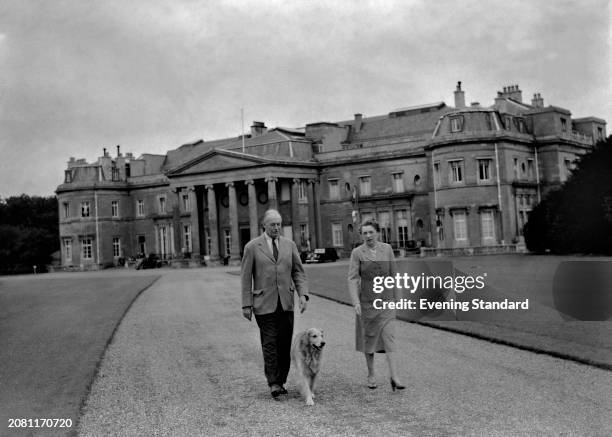 Sir Harold Wernher 1893-1973) with his wife, Lady Anastasia Mikhailovna Wernher walking their Labrador Retriever outside their stately home Luton...