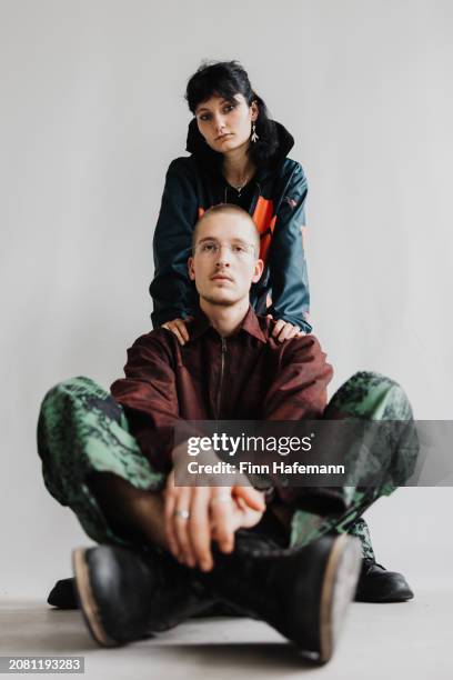 two beautiful millennials are wearing
baggy fashion clothes and looking at the camera - shoe boot stock pictures, royalty-free photos & images