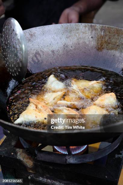 frying samosas in the ancient city of hampi, india - samosa stock pictures, royalty-free photos & images