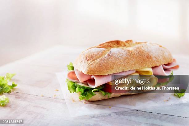 baguette with ham, cheese, vegetables and lettuce - krulandijvie stockfoto's en -beelden