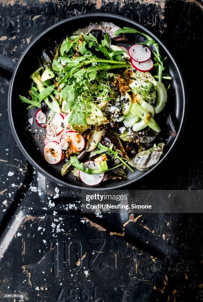 A green salad with radishes, spring onion and tahini