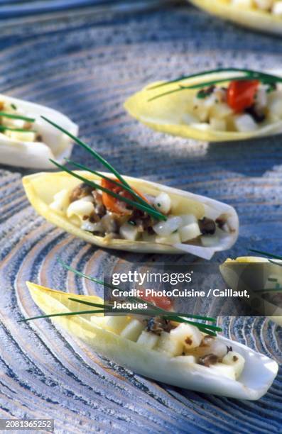 chicory boats with scallops, green apple and chives on a blue surface - witloof chicory stock pictures, royalty-free photos & images