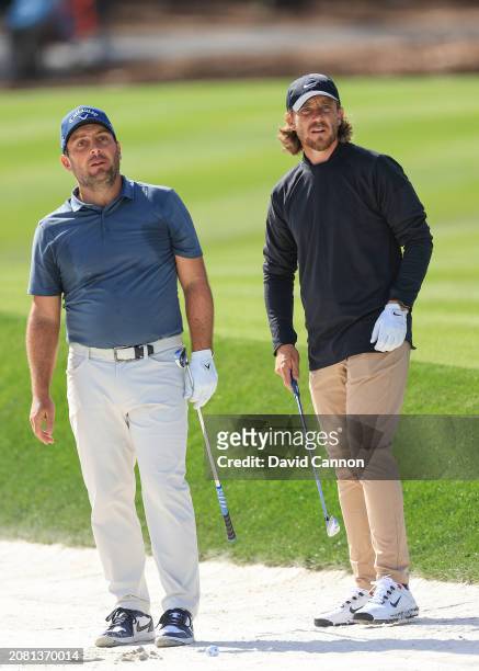 Francesco Molinari of Italy plays a shot during a practice round watched by Tommy Fleetwood of England prior to THE PLAYERS Championship on the...