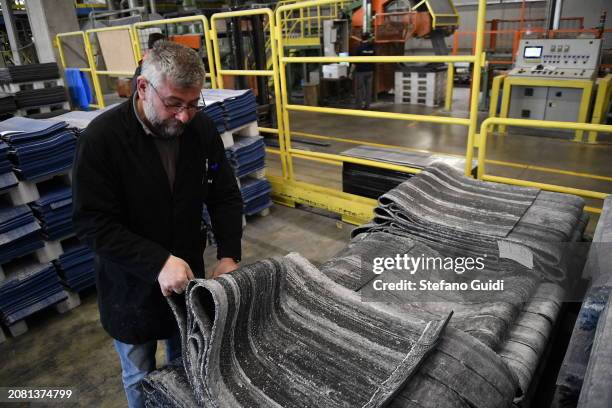 Worker inside Mondo factory during the construction of the athletes track for the Paris Olympic and Paralympic Games on March 13, 2024 in Alba,...