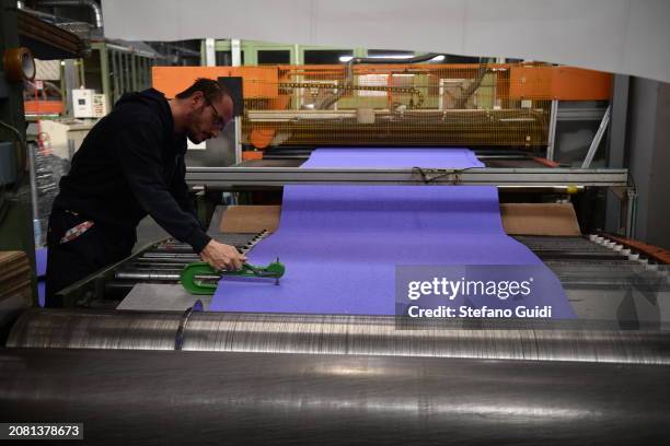 Worker inside Mondo factory during the construction of the athletes track for the Paris Olympic and Paralympic Games on March 13, 2024 in Alba,...