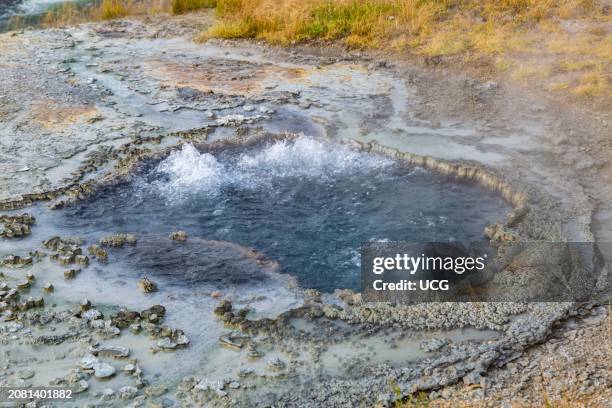 Bubbling water from hot springs flows into the Firehole River in the Upper Geyser Basin at Yellowstone National Park.