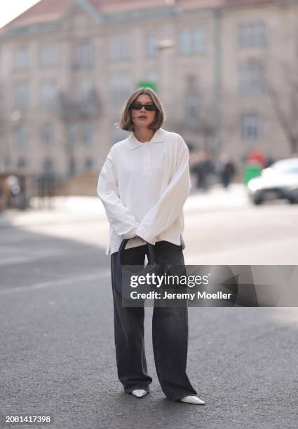 Sophia Geiss seen wearing YSL black sunglasses, COS white cotton buttoned polo sweater, Drykorn grey baggy wide leg denim pants / jeans, Coperni...