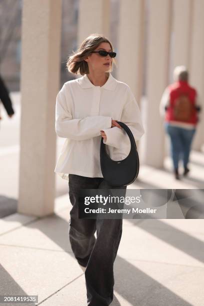 Sophia Geiss seen wearing YSL black sunglasses, COS white cotton buttoned polo sweater, Drykorn grey baggy wide leg denim pants / jeans and Coperni...