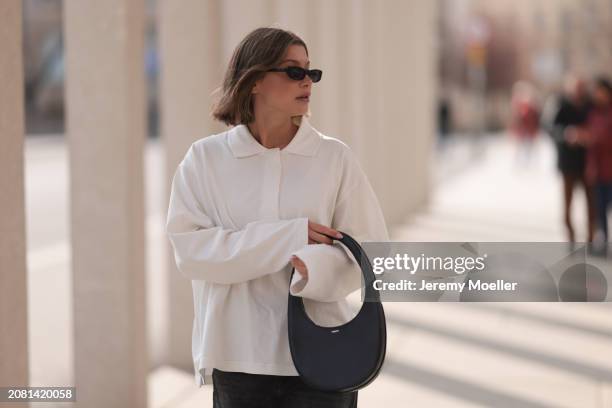 Sophia Geiss seen wearing YSL black sunglasses, COS white cotton buttoned polo sweater, Drykorn grey baggy wide leg denim pants / jeans and Coperni...