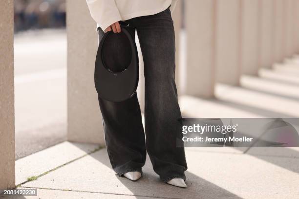 Sophia Geiss, detail, seen wearing COS white cotton buttoned polo sweater, Drykorn grey baggy wide leg denim pants / jeans, Coperni black leather bag...