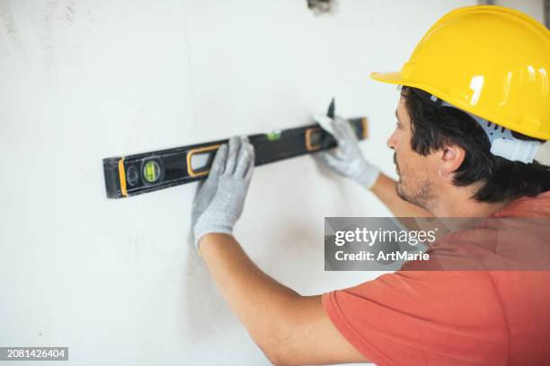 construction worker using leveling tool during interior decoration/reconstruction - spirit level stock pictures, royalty-free photos & images
