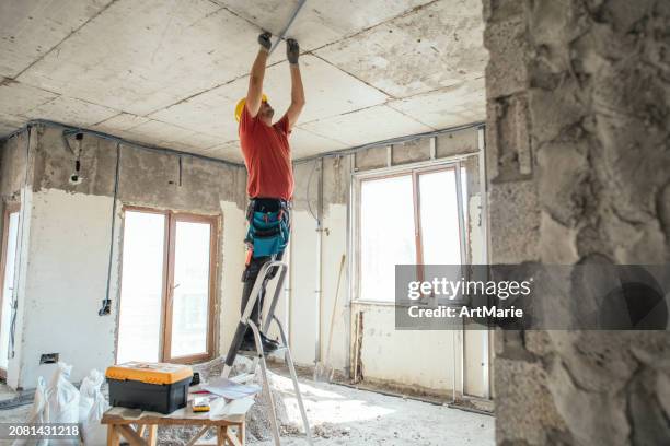 elektriker, der auf einer baustelle während der renovierung, reparatur oder des wiederaufbaus von häusern oder wohnungen arbeitet - elektrische sicherung stock-fotos und bilder