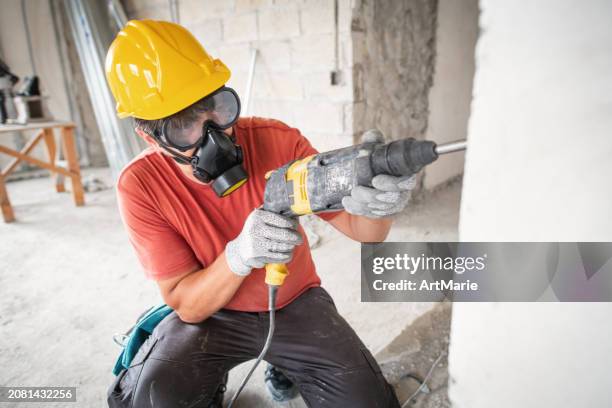 worker using hammer drill at a construction site - jackhammer stock pictures, royalty-free photos & images