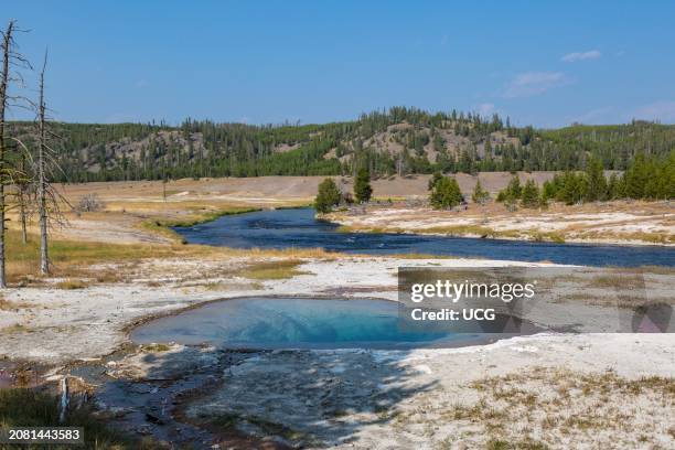 Water from geysers and hot springs flows into the Firehole River through the Midway Geyser Basin in Yellowstone National Park, Wyoming.