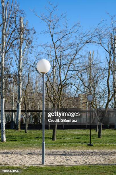 a park on a sunny day with a street lamp in the foreground - edison new jersey stock pictures, royalty-free photos & images