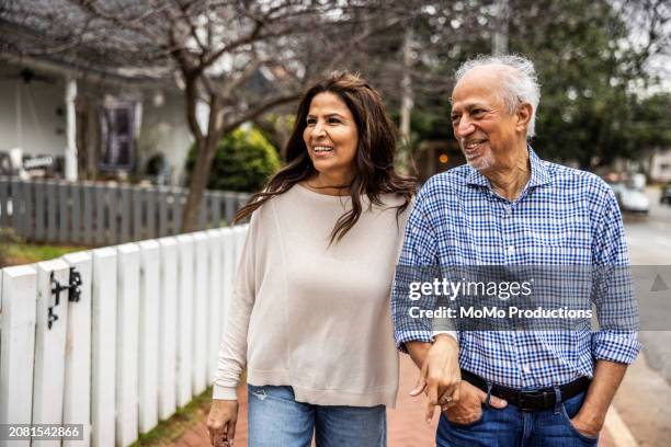 senior couple walking down suburban street - asian wife stock pictures, royalty-free photos & images