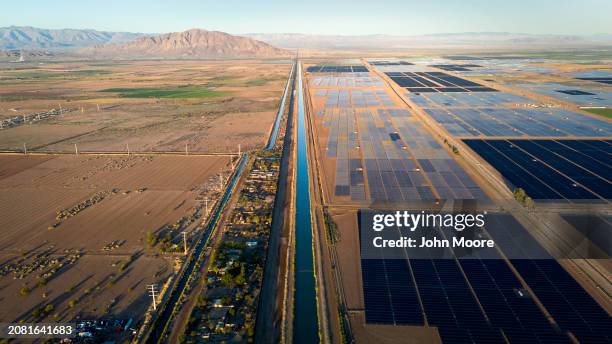 In an aerial view, solar farms and the All-American Canal stretch along the U.S.-Mexico border fence on March 8, 2024 in Calexico, California. Water...