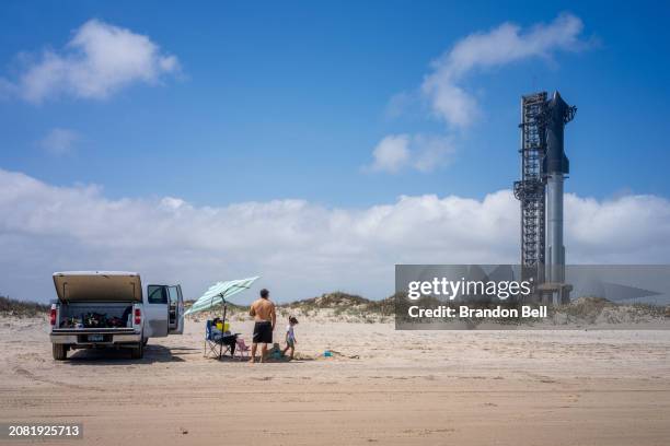 Family spends time together on the shore near the Starship Flight 3 Rocket a day before its scheduled launch at the Starbase facility near Boca Chica...