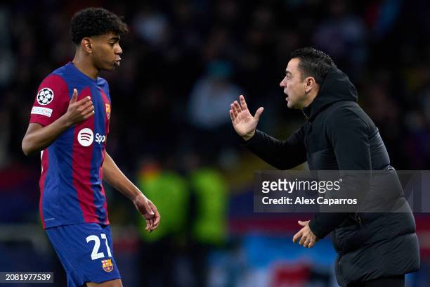 Barcelona Head Coach Xavi Hernandez interacts with Lamine Yamal of FC Barcelona during the UEFA Champions League 2023/24 round of 16 second leg match...