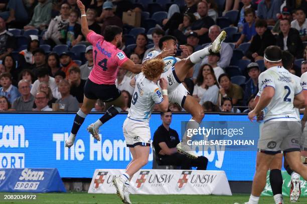 Waratahs' Tane Edmed and Blues' Mark Tele'a fight for the ball during the Super Rugby match between the NSW Waratahs and the Blues in Sydney on March...