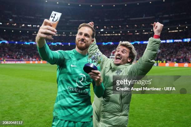 Jan Oblak of Atletico Madrid poses for a photo with the PlayStation Player Of The Match award alongside teammate Antoine Griezmann after the team's...