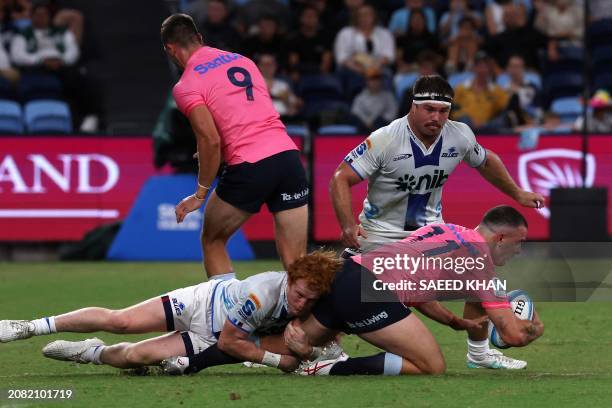 Blues' Finlay Christie tackles Waratahs' Dylan Pietsch during the Super Rugby match between the NSW Waratahs and the Blues in Sydney on March 16,...