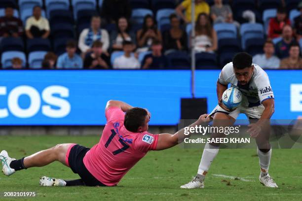 Waratahs' Dylan Pietsch tackles Blues' Stephen Perofeta during the Super Rugby match between the NSW Waratahs and the Blues in Sydney on March 16,...