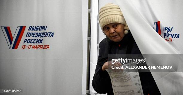 Woman leaves a voting booth to cast her ballot in Russia's presidential election at a polling station in Sergiyev Posad, some 75 kilometres...