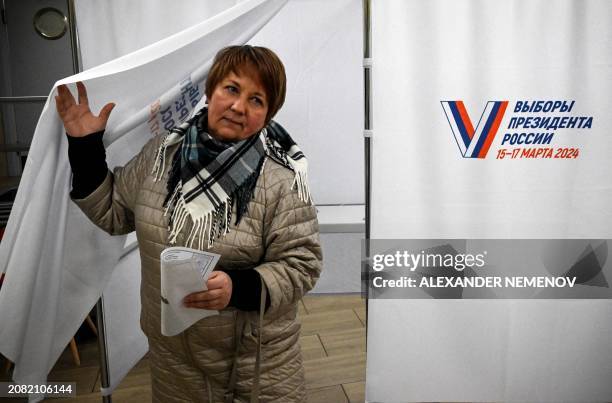 Woman leaves a voting booth to cast her ballot in Russia's presidential election at a polling station in Sergiyev Posad, some 75 kilometres...