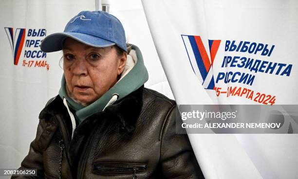 Woman leaves a voting booth to cast her ballot in Russia's presidential election at a polling station in Sergiyev Posad, some 75 kilometres...