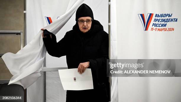 An Orthodox nun leaves a voting booth to cast her ballot in Russia's presidential election at a polling station in Sergiyev Posad, some 75 kilometres...