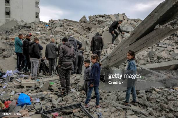 Palestinians inspect the rubble of a building, after it was destroyed in an Israeli strike the night before, in the Rimal neighbourhood of Gaza City...