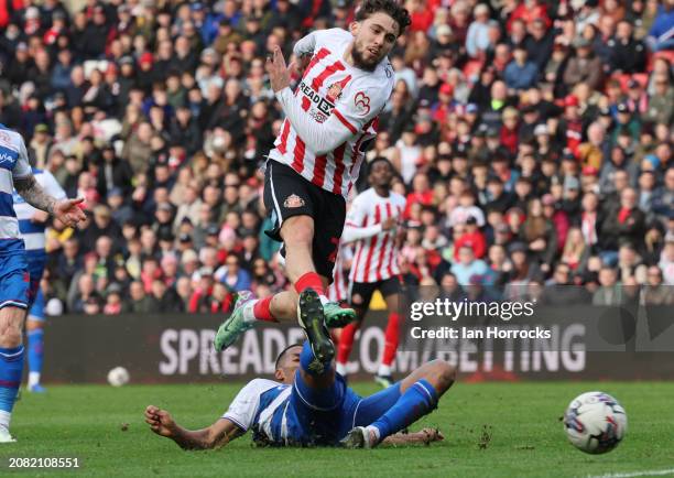 Adil Aouchiche of Sunderland is tackled as he takes his shot during the Sky Bet Championship match between Sunderland and Queens Park Rangers at...