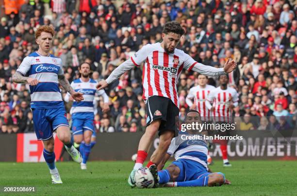 Adil Aouchiche of Sunderland is tackled as he takes his shot during the Sky Bet Championship match between Sunderland and Queens Park Rangers at...