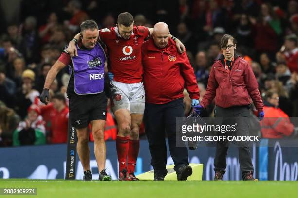 Wales' centre George North is helped to leave the pitch following an injury during the Six Nations international rugby union match between Wales and...