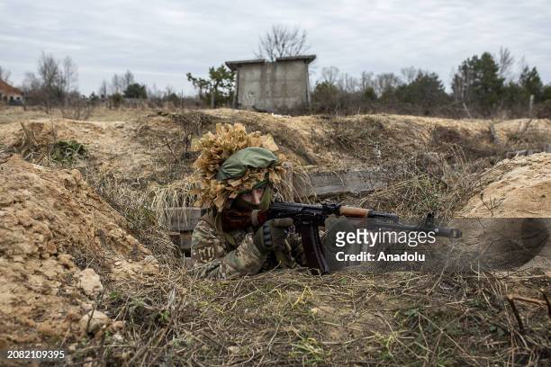 Member of 120th Independent Brigade of the Territorial Defense Forces of Ukraine takes part in training exercises as he wears camouflage in a trench...
