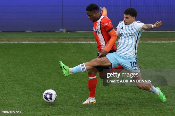 Luton Town's Irish midfielder Chiedozie Ogbene vies with Nottingham Forest's English midfielder Morgan Gibbs-White during the English Premier League...