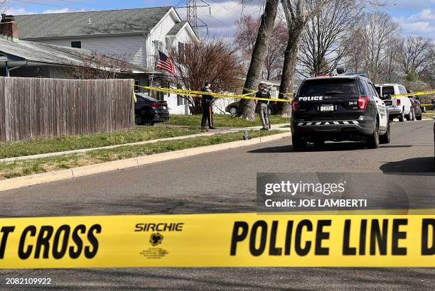 Police guard a home during an active shooter situation in Levittown, a community within Falls Township, Pennsylvania, on March 16, 2024. Three people...