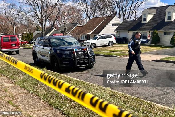 Police officer patrols a neighborhood during an active shooter situation in Levittown, a community within Falls Township, Pennsylvania, where a a...