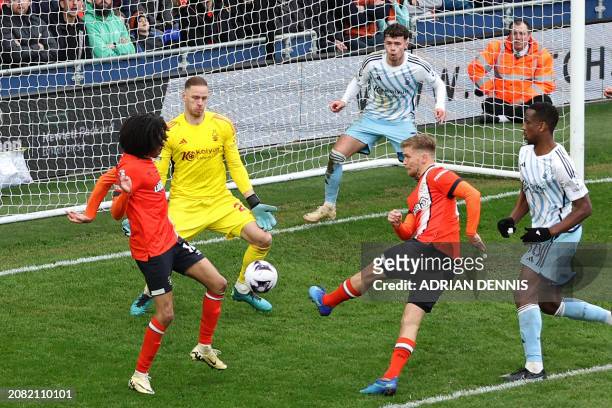 Luton Town's English midfielder Luke Berry shoots to score their first goal during the English Premier League football match between Luton Town and...