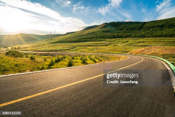 grasslands and road - genomfart bildbanksfoton och bilder