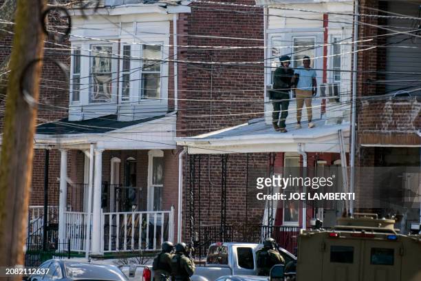 Police remove people from a home in Trenton New Jersey, on March 16 after reports of a gunman, who is suspected of a shooting spree in Pennsylvania,...